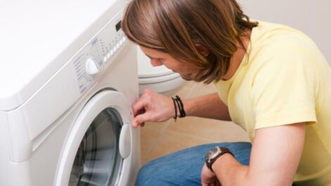 A man opening a washer or dryer
