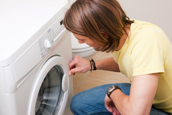 A man opening a washer or dryer