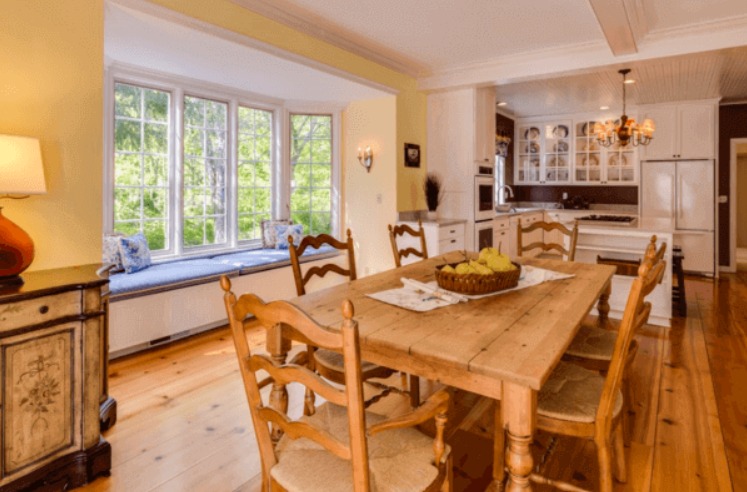 A home kitchen and dining space from the perspective of the dining area, including a dining room table set for four.