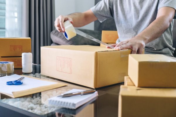 business owner taping a box shut