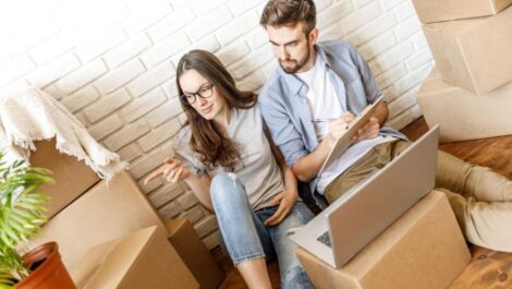 Man and woman sitting by packaged boxes.