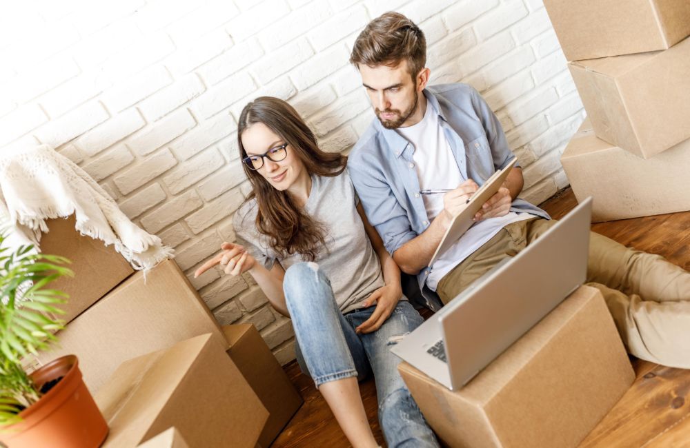 Man and woman sitting by packaged boxes.