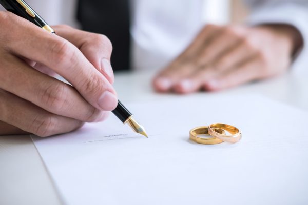 A man signing divorce papers