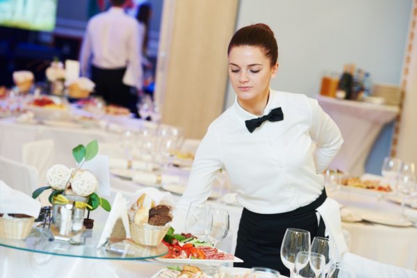 A restaurant worker with catering supplies