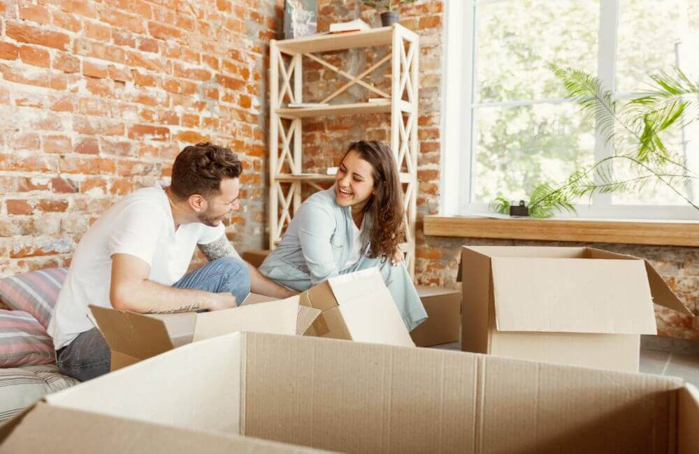 A young couple unpacking boxes in their new shared home