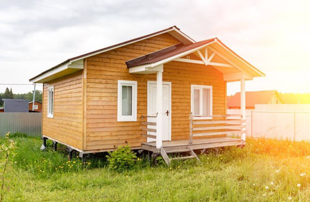 A tiny home of wood on a small patch of land.