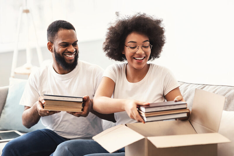 A young couple packs books first for their move to a new home.
