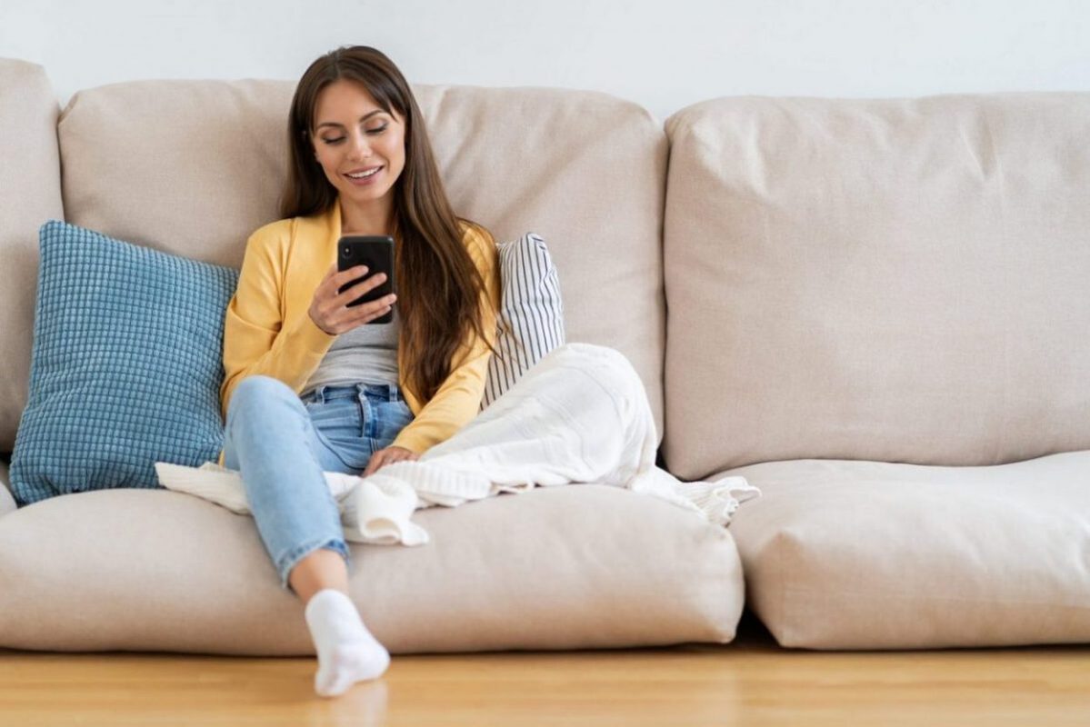 A woman relaxes on the couch without worrying about missing her storage payment.