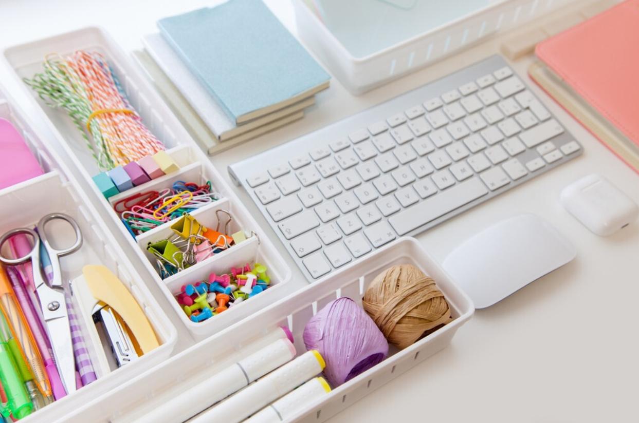 A keyboard and drawer insert with various organized craft supplies arranged across a tabletop.