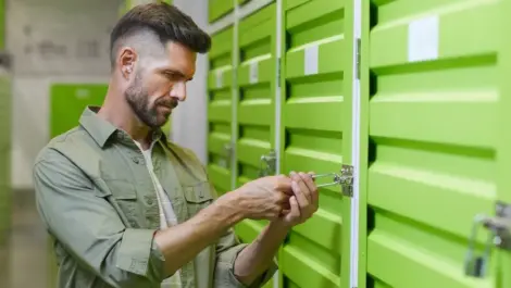 Adult opening an interior storage unit door by padlock.