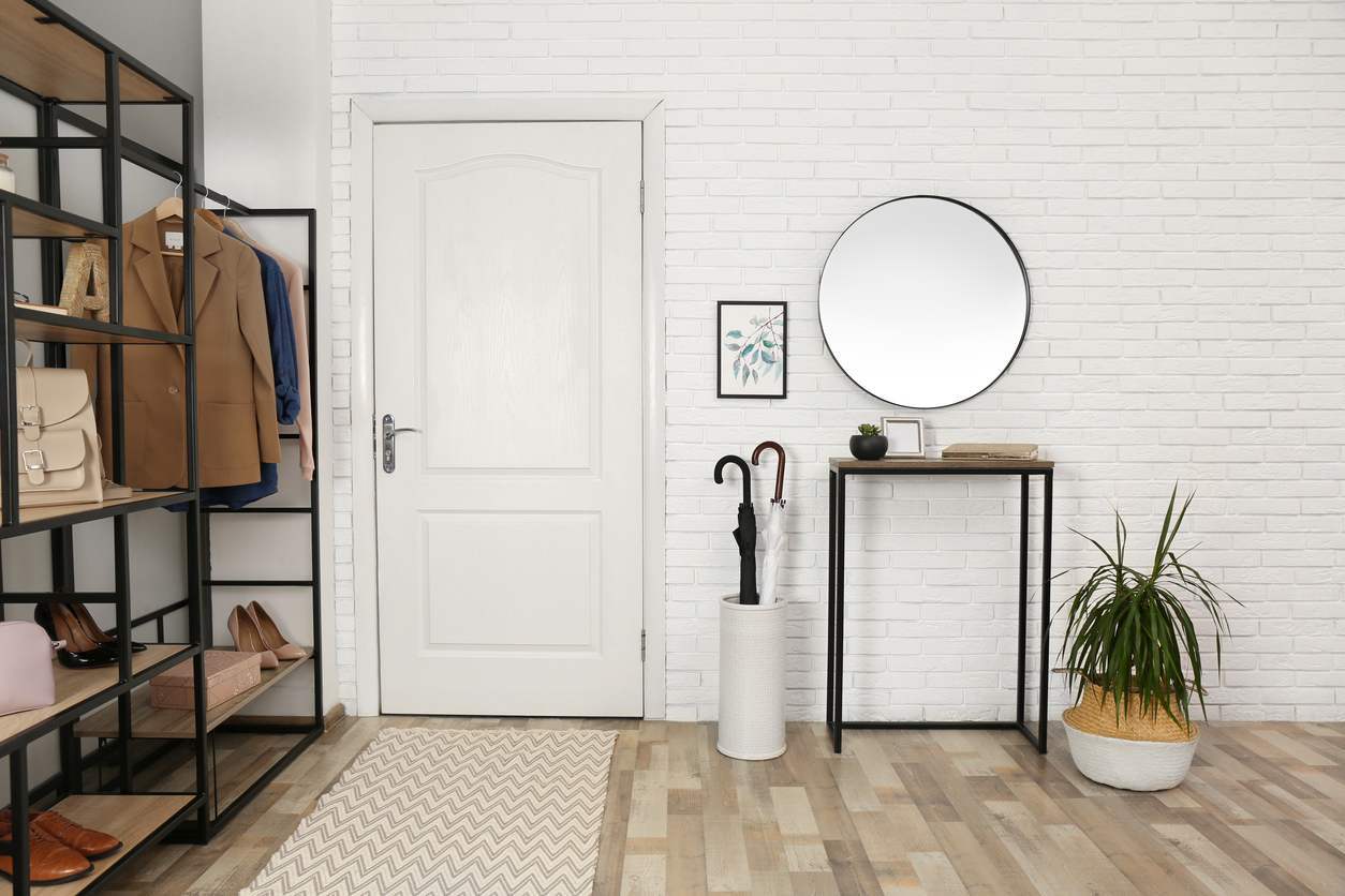 Photo of an organized home's entry space, including shelving space and umbrella stand.