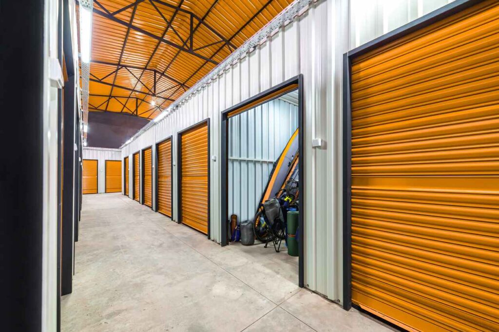 A clean, bright hallway of indoor storage units suitable for storing kayaks and other water gear.